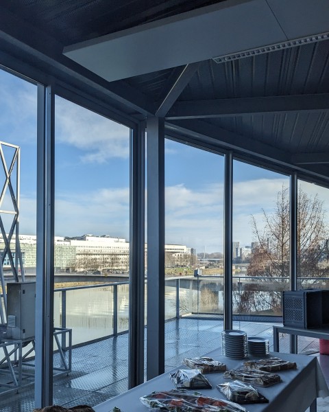 The milky way above a foggy landscape with mountains in the background and a forest in the foreground.